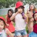 Happy children and adults enjoying bubble-blowing in a sunny park, creating joyful summer memories.